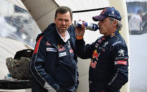 Peugeot's Spanish driver Carlos Sainz (R) drinks at the end of Stage 8 of the 2018 Dakar Rally between Uyuni and Tupiza, Bolivia, on January 14, 2018. (AFP)