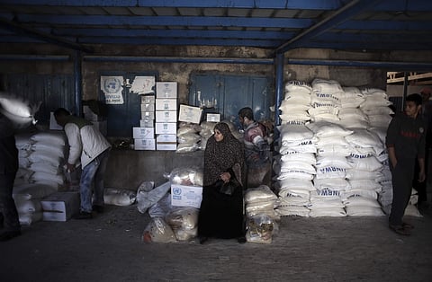In this Sunday Jan. 14, 2018 photo, a Palestinian woman waits to receive food aid at a U.N. warehouse in the Shati refugee camp, Gaza City. (Photo | Associated Press)