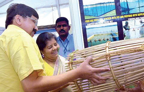 CMFRI director A Gopalakrishnan showing Fisheries Minister J Mercykutty Amma an 'Ottal', a fish trapping tool, at the Aqua-Agri-Food fest as part of SAFARI-2 in Kochi on Wednesday