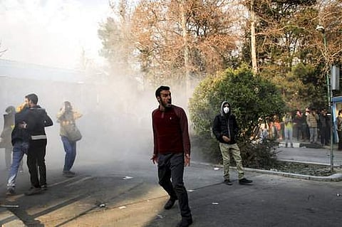 In this photo taken by an individual not employed by the Associated Press and obtained by the AP outside Iran, university students attend a protest inside Tehran University while a smoke grenade is thrown by anti-riot Iranian police, in Tehran, Iran, Satu