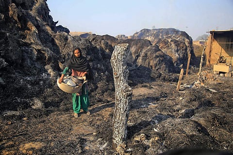 A woman from Gujjar tribe collects all her belongings at a temporary shed damaged in the cross-border shelling by Pakistan at the international border at Jora Farm village in Jammu on Saturday. | PTI