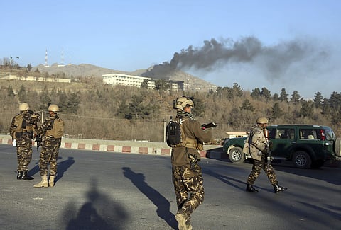 Afghan security personnel stand guard as black smoke rises from the Intercontinental Hotel after the attack | AP