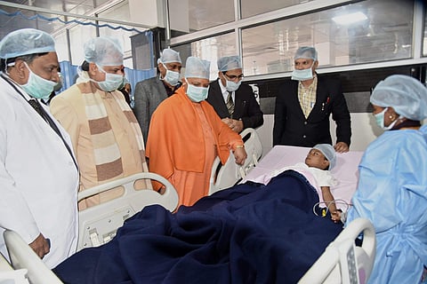 Uttar Pradesh Chief Minister Yogi Adityanath meets the injured Class I student at King George’s Medical University in Lucknow. (File | PTI)