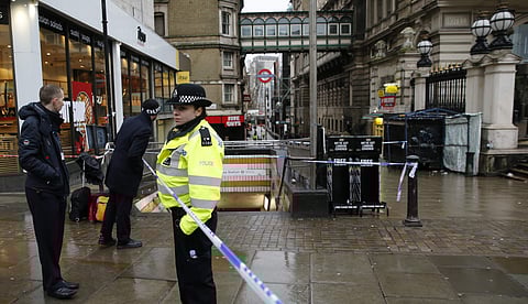 Commuters look past a police cordon as they get to their place of work in the area near a major gas leak near Charing Cross railway station in central London | AP