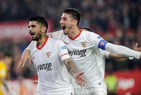 Sevilla's Argentinian midfielder Ever Banega (L) celebrates with Sergio Escudero after scoring a goal during the match. | Photo: AFP