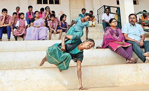 A differently-abled athlete using her hands to get down the stairs and reach the playing arena at the Anna Stadium in Tiruchy on Tuesday | m k ashok kumar