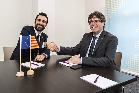 Ousted Catalan leader Carles Puigdemont, right, shakes hands with the President of the Parliament of Catalonia Roger Torrent | AP