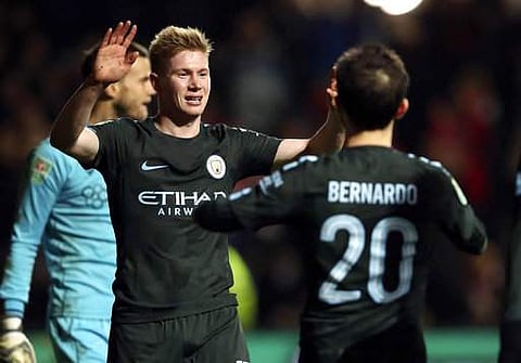 Manchester City's Kevin De Bruyne, left, celebrates scoring his side's third goal of the game during the English League Cup semi final, second leg match against Bristol City at Ashton Gate. | Photo: AP