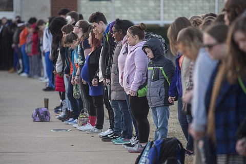 Students and community members hold hands in prayer before classes at Paducah Tilghman High School in Paducah, Ky., Wednesday, Jan. 24, 2018. The gathering was held for the victims of the Marshall County High School shooting on Tuesday. (Ryan Hermens/The 