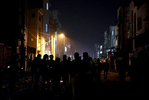 This picture shows policemen and security personnel standing outside a burnt firecracker factory on the outskirts of New Delhi.  (File | AP)