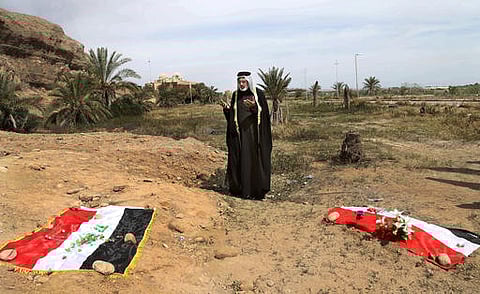 In this file picture, an Iraqi man prays for his slain relative, at the site of a mass grave, believed to contain the bodies of Iraqi soldiers killed by Islamic State group militants when they overran Camp Speicher military base, in Tikrit, Iraq. (AP)