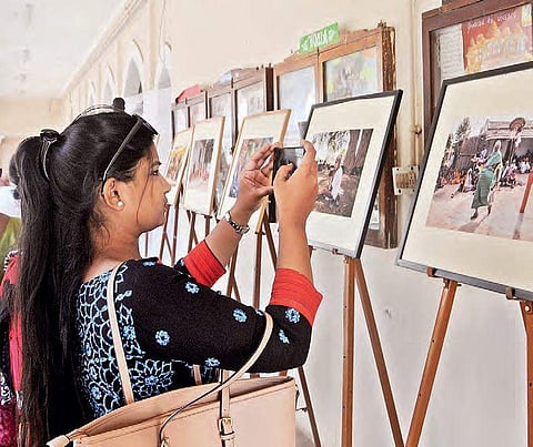 A girl takes a picture at the photo exhibition on the second day of Lit Fest in Hyderabad on Saturday