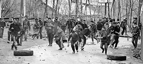 A file photo of Kashmiri youths throwing stones at security forces.
