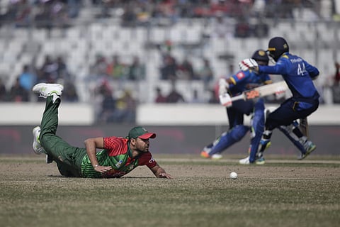 Bangladesh's captain Mashrafe Mortaza, fore ground, drives to stop the ball, while Sri Lanka's Upul Tharanga and teammate Niroshan Dickwella run between the wickets during the final match of the Tri-Nation series in Dhaka. | AP