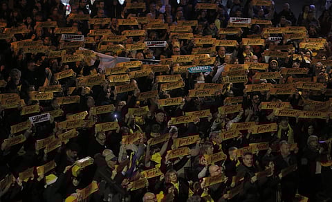 Pro-independence demonstrators holding banners reading in Catalan 'Freedom for the political prisoners.' | AP
