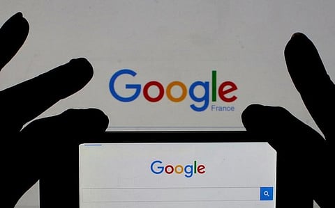 A woman holds her smart phone which displays the Google home page, in this picture illustration. | Reuters
