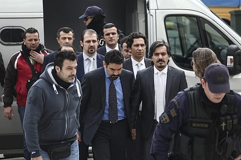 In this Thursday, Jan. 26, 2017 file photo Turkish military officers, center, escorted by Greek police officers, arrive at the Supreme Court in Athens. (Associated Press)