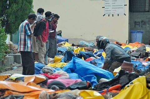 Indonesian police carry the body of a tsunami victim during a mass burial in Palu, Central Sulawesi, Indonesia, Monday, Oct. 1, 2018. (Photo | AFP)
