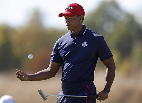 Tiger Woods of the US picks up his ball on the 5th green during a singles match on the final day of the 42nd Ryder Cup at Le Golf National in Saint-Quentin-en-Yvelines, outside Paris. | AP