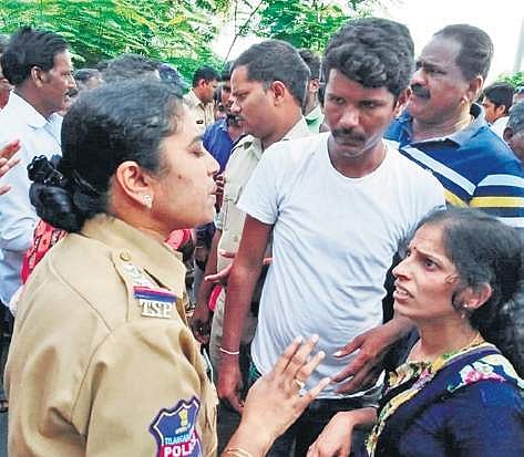 Police try to pacify relatives of Gaddi Kumar (inset) in Karimnagar on Tuesday. His body was found in a cotton field two days after he went missing | express