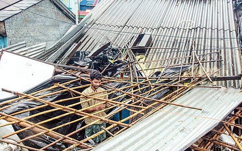 A man repairs his shop which was destroyed by cyclone Titli at Baruva village in Srikakulam district | EPS