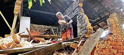 A woman at her damaged house that bore the brunt of the mid-August deluge