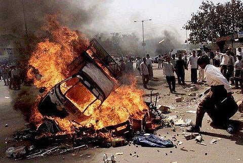 Vehicles on fire in Ahmedabad, India, on Feb. 28, 2002, the day 69 Muslims, mostly women and children, died in a compound set ablaze by thousands of Hindu men armed with stones, iron rods and bombs. (Photo | AP)