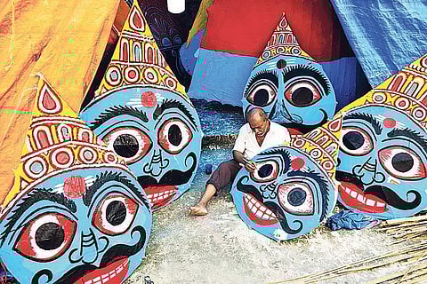 An artisan painting the masks to be used as heads of King Ravana’s idol, which will be set to fire on Dasami day of Dussehra, in Bhubaneswar on Sunday I Express