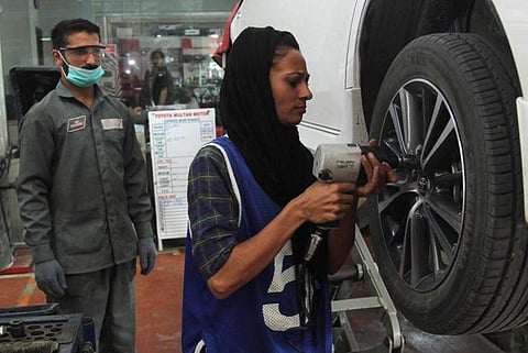 Pakistani motor mechanic Uzma Nawaz, 24, fixes a car at an auto workshop in Multan. (Photo| AFP)