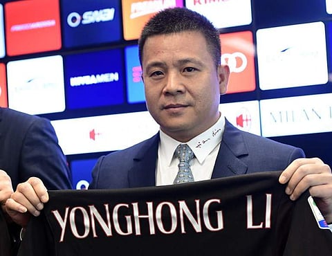 This file picture taken on April 14, 2017 shows Yonghong Li, then-owner of the AC Milan football club, posing with a jersey of the club during a press conference in Milan. (Photo | AFP)