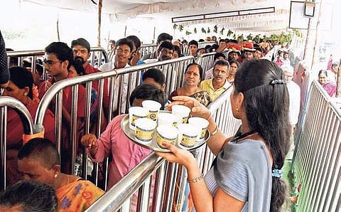 NSS volounteers supplying free milk for children in queue during Navratri celebrations in Vijayawada on Wednesday | EXPRESS