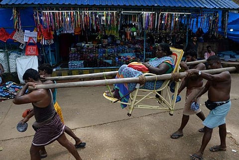 A devotee is carried in a palanquin to the Lord Ayyappa temple at Sabarimala in the southern state of Kerala. | AFP