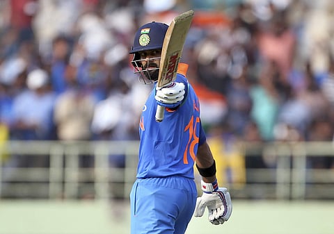 India's captain Virat Kohli raises his bat to celebrate scoring fifty runs during the second one-day international cricket match between India and West Indies in Visakhapatnam. (Photo | AP)