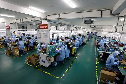 Employees work at the assembly line inside TMB's mobile phone battery manufacturing plant in Noida, India. (Photo: Reuters)