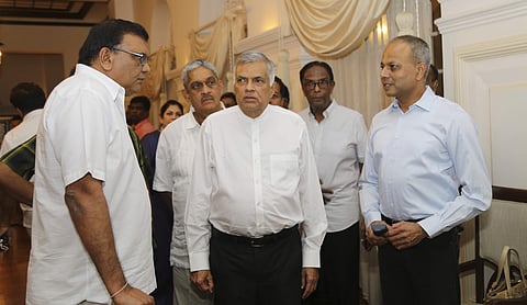 Sri Lanka's sacked prime minister Ranil Wickremesinghe (C) speaks with party members at his official residence in Colombo | AP