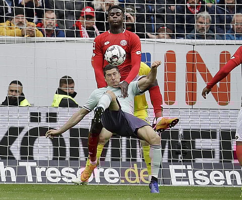 Bayern forward Robert Lewandowski, bottom, and Mainz's Moussa Niakhate challenge for the ball during a German Bundesliga soccer match between FSV Mainz 05 and Bayern Munich in Mainz, Oct. 27, 2018. (Photo | AP)