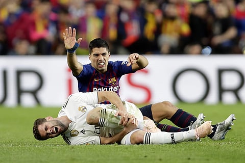 With the injured Lionel Messi watching from the Camp Nou stands, Luis Suarez scored a hat trick to lead Barcelona to a 5-1 rout of Real Madrid in the Spanish league on Sunday. (Photo | AP)