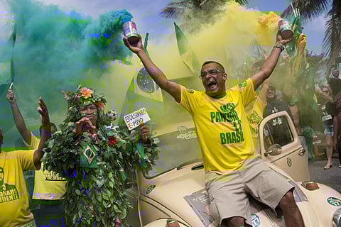Supporters of presidential front-runner Jair Bolsonaro sing the national anthem outside his residence in Rio de Janeiro, Brazil, Sunday, Oct. 28, 2018, during the country's presidential runoff election. | AP