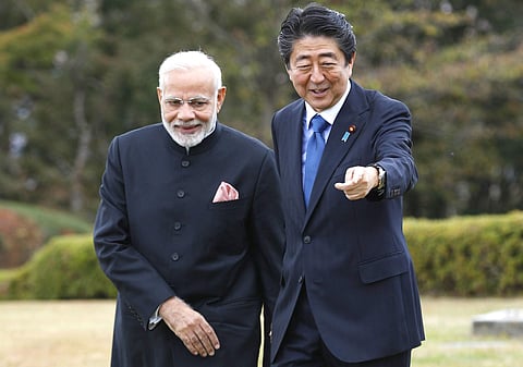 Prime Minister Narendra Modi, left, and Japan's Prime Minister Shinzo Abe walk together at a hotel garden in Yamanakako village, Yamanashi prefecture. (Photo | AP)