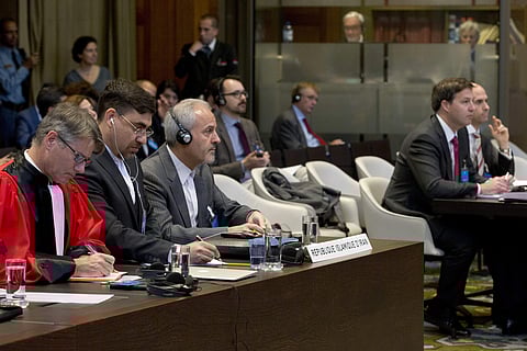Mohammed Zahedin Labbaf, third left, agent for the Islamic Republic of Iran, and the U.S. delegation, right, listen to the ruling of the judges on an Iranian request to order Washington to suspend sanctions against Tehran, at the International Court of Ju