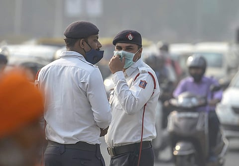 Traffic policemen wear masks to protect themselves as air quality deteriorates in New Delhi. (Photo|PTI)