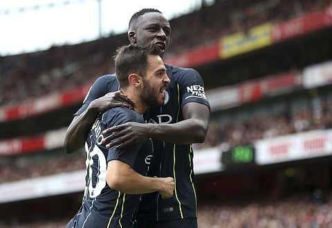 Manchester City's Bernardo Silva, left, celebrates with Benjamin Mendy after scoring his side's second goal of the game during the English Premier League soccer match between Arsenal and Manchester City at the Emirates Stadium, London. Sunday Aug. 12, 201