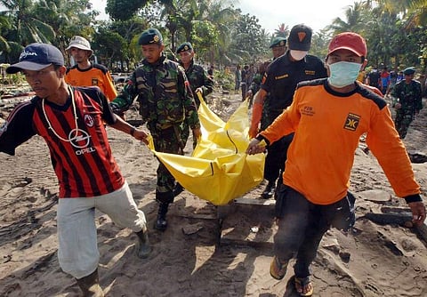 Indonesian military and rescuers carry a dead body in Pangandaran 20 July 2006, three-days after strong earthquake-triggered tsunami hit south coast of Java island. Aid efforts cranked into higher gear to assist Indonesian tsunami survivors a day after an