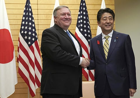 U.S. Secretary of State Mike Pompeo, left, shakes hands with Japanese Prime Minister Shinzo Abe at Abe's office in Tokyo. (Photo | AP)
