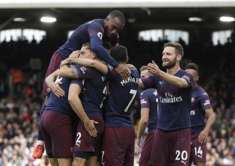 Arsenal's Aaron Ramsey celebrates with teammates after he scored his side's third goal during the English Premier League soccer match between Fulham and Arsenal at Craven Cottage stadium in London. (Photo | AP)