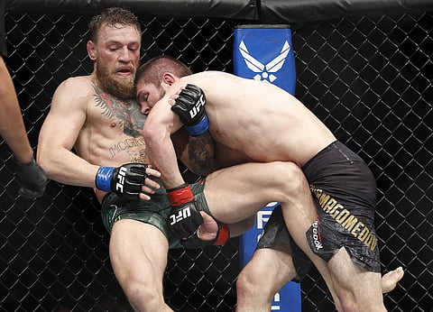 Khabib Nurmagomedov, right, tries to take down Conor McGregor during a lightweight title mixed martial arts bout at UFC 229 in Las Vegas. (Photo | AP)