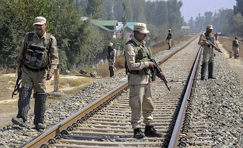 Security personnel stand guard on the railway tracks during a strike call given by the joint Hurriyat leadership against the municipal elections in Srinagar. (Photo | PTI)