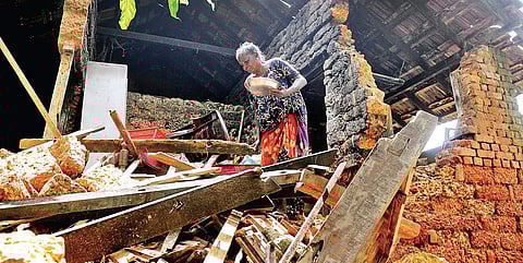 A woman at her damaged house that bore the brunt of the mid-August deluge