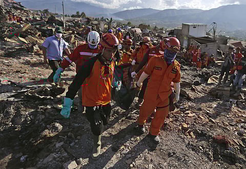 Rescuers remove the body of an earthquake victim from the devastated village of Balaroa in Palu, Central Sulawesi, Indonesia, Monday, Oct. 8, 2018. (Photo | AP)