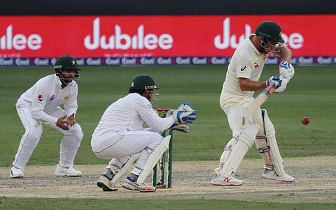 Australian cricketer Aaron Finch (R) plays a shot during day two of the first Test match in the series between Australia and Pakistan in Dubai on October 8, 2018.  | AFP
